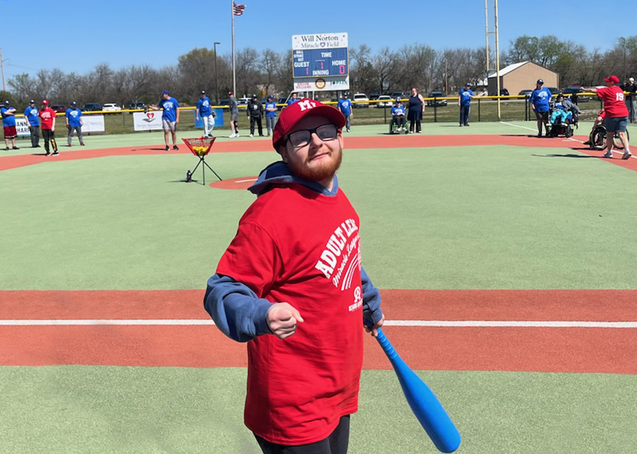 Miracle League player on the field with a bat