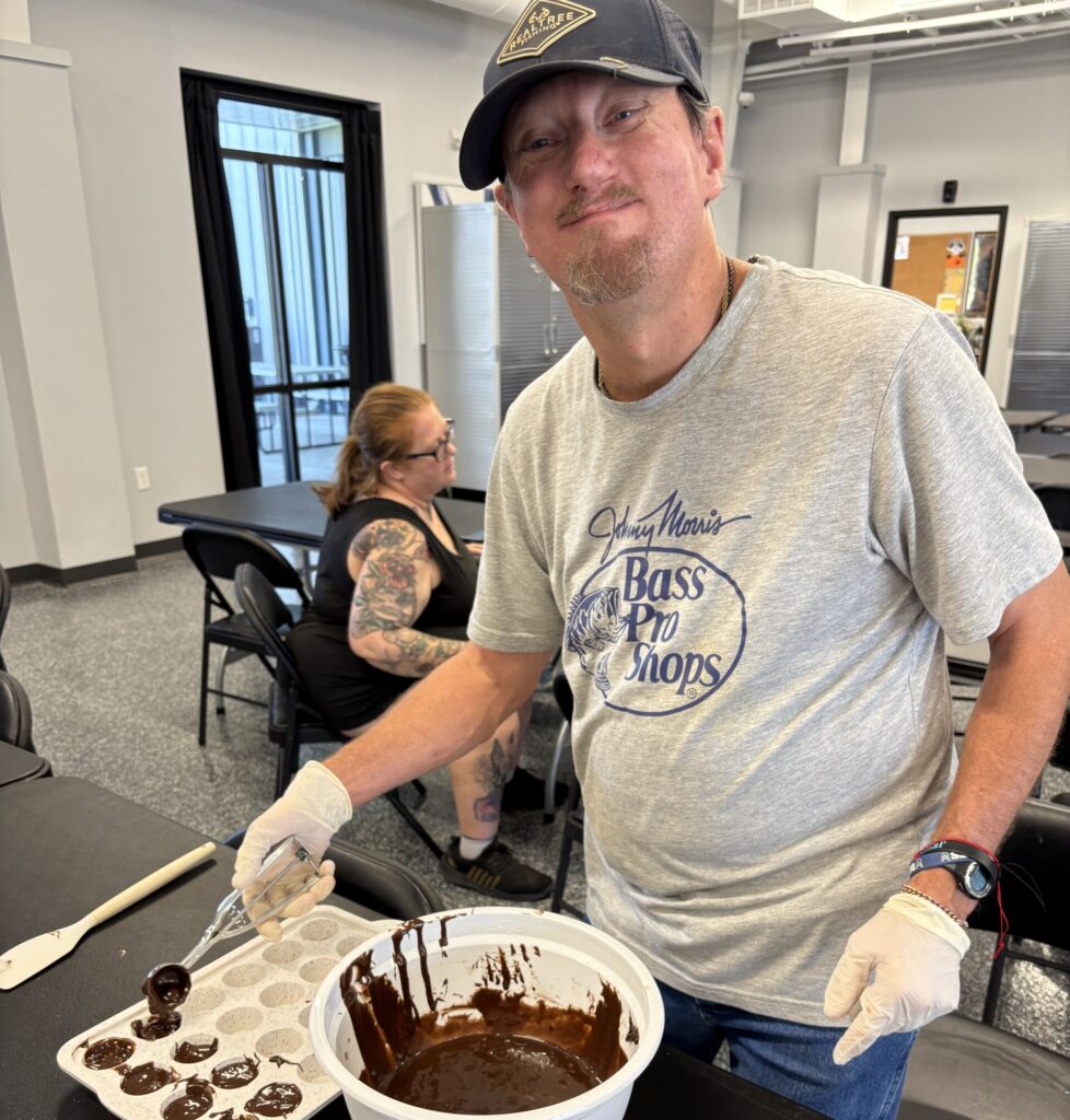 member smiling as they are making brownies